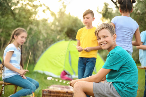 Children roasting marshmallow on fire at summer camp