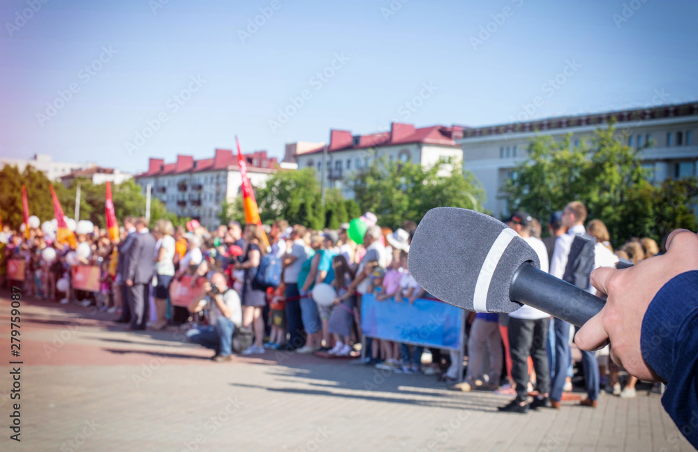 Obraz premium The microphone on the background of a crowd of people in the square concept of freedom of speech and interview. Rally on the square, strike, copy space, public opinion