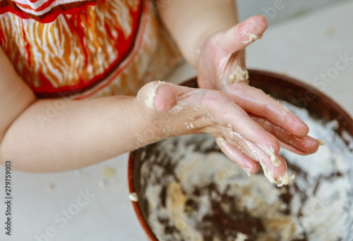 baby hands knead the dough in a pizza plate