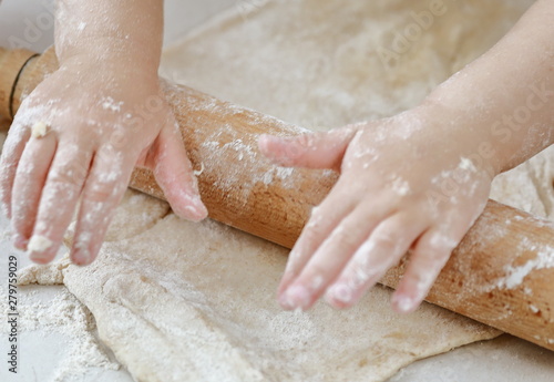 baby hands rolling dough with a rolling pin