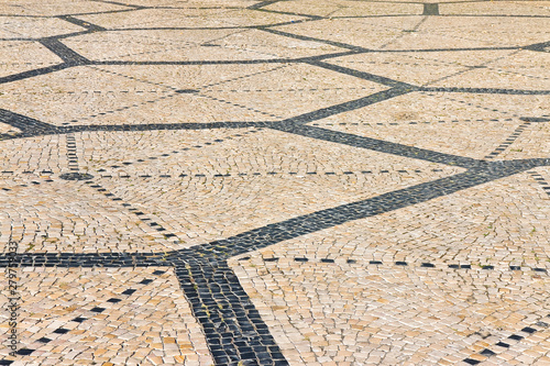 Typical portuguese floor made of small pieces of black and pink stone (Portugal - Europe)