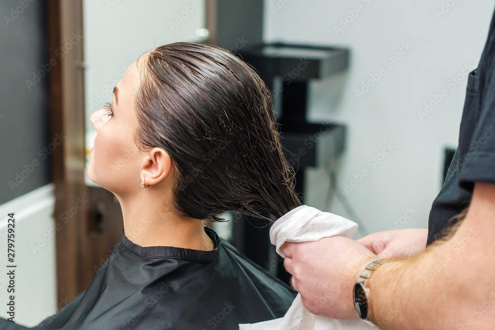 Professional hairdresser wiping hair of her client Professional hairdresser wiping hair of her client