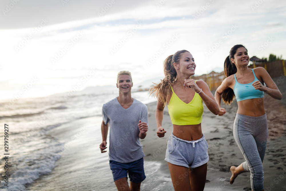 Group of friends running at the beach on beautiful summer sunset Group of friends running at the beach on beautiful summer sunset