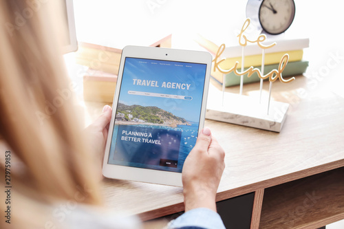 Photography Woman with tablet computer visiting travel agency website at home