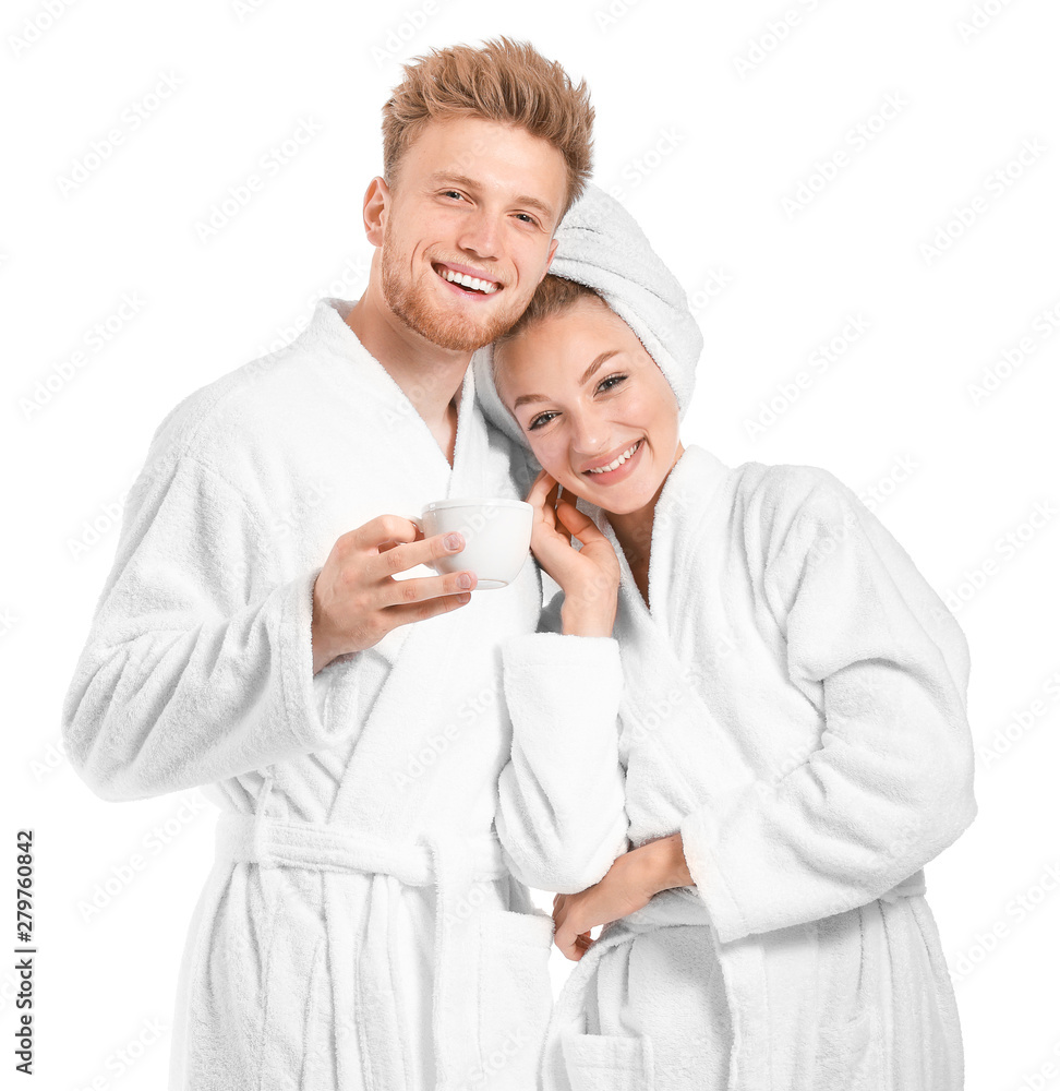 Happy young couple in bathrobes and with cup of coffee on white background Happy young couple in bathrobes and with cup of coffee on white background