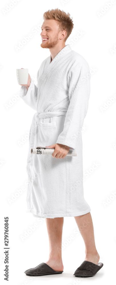 Handsome young man in bathrobe holding cup of coffee and newspaper on white background Handsome young man in bathrobe holding cup of coffee and newspaper on white background