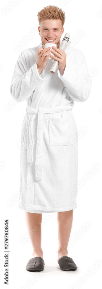 Handsome young man in bathrobe holding cup of coffee and newspaper on white background Handsome young man in bathrobe holding cup of coffee and newspaper on white background
