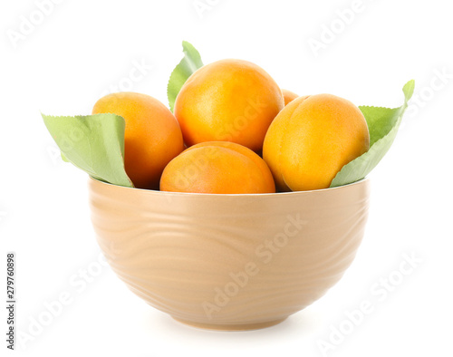 Bowl with tasty ripe apricots on white background