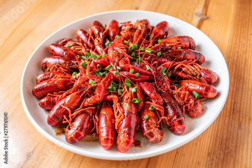 A large bowl of delicious braised crayfish on a wooden table