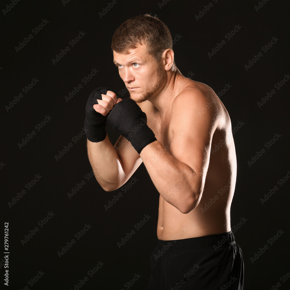 Strong male boxer on dark background