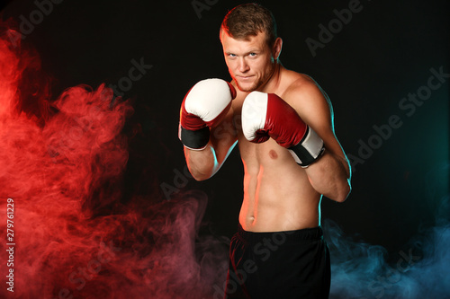 Strong male boxer on dark b...