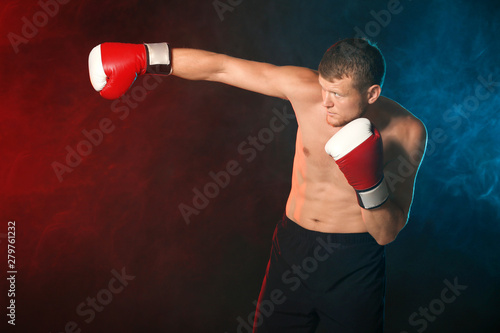Strong male boxer on dark b...