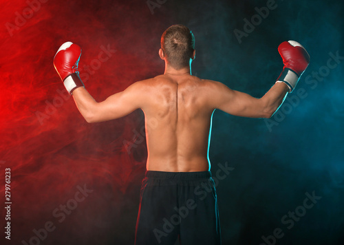 Strong male boxer on dark background