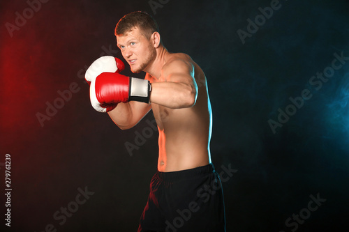 Strong male boxer on dark b...