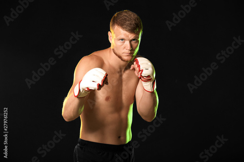 Strong male boxer on dark b...