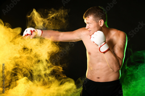 Strong male boxer in smoke ...
