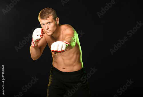 Strong male boxer on dark b...