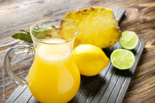 Jug of fresh pineapple juice on table