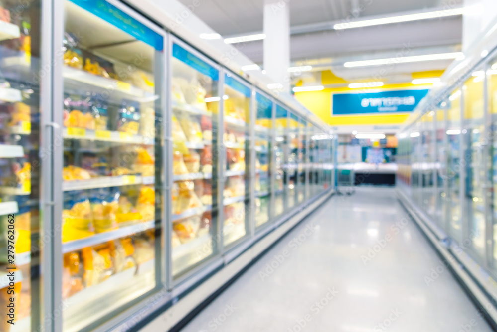 Frozen food on shelf in freezers at supermarket. Blurred background for