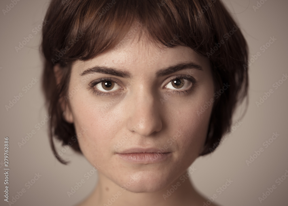 Natural portrait of young attractive woman looking and posing with neutral face expression Natural portrait of young attractive woman looking and posing with neutral face expression