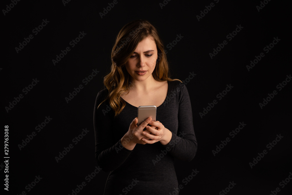 Serious frustrated girl holding phone in arm and do not understand what is going on Serious frustrated girl holding phone in arm and do not understand what is going on