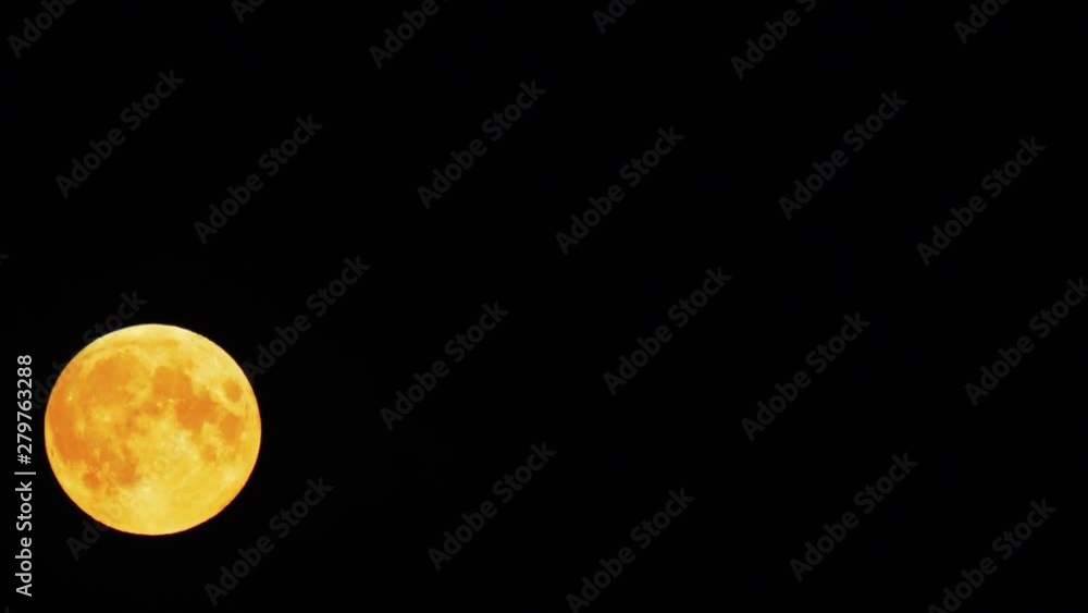 A full moon of yellow color is floating against the black sky. Time lapse loop able video. A full moon of yellow color is floating against the black sky. Time lapse loop able video.