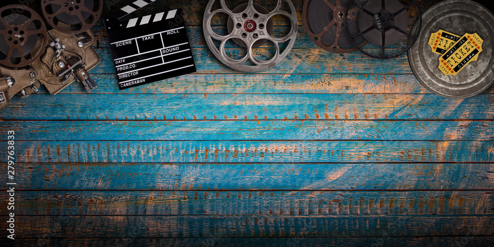 Cinema concept of vintage film reels, clapperboard and projector on old  wooden background. Stock Photo