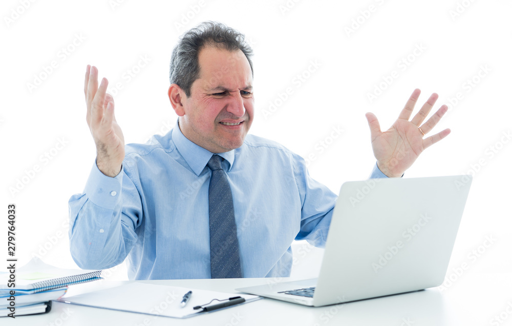 Overwhelmed and desperate mature businessman working with laptop feeling angry and furious at office Overwhelmed and desperate mature businessman working with laptop feeling angry and furious at office