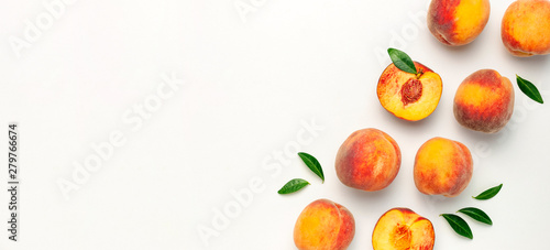Fototapeta Naklejka Na Ścianę i Meble -  Flat lay composition with peaches. Ripe juicy peaches with green leaves on white background. Flat lay, top view, copy space. Fresh organic fruit, vegan food. Harvest concept