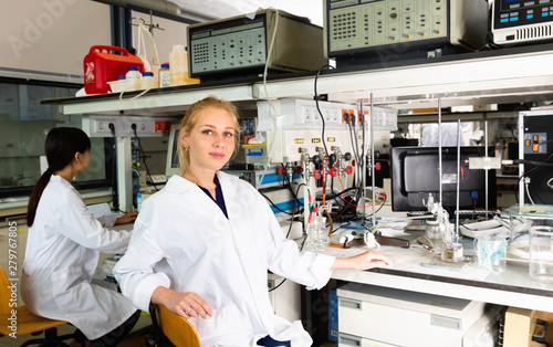 Portrait of young female scientist near laboratory equipment at biochemical lab