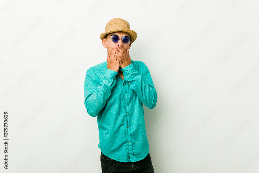 Young hispanic man wearing a summer clothes shocked covering mouth with hands. Young hispanic man wearing a summer clothes shocked covering mouth with hands.