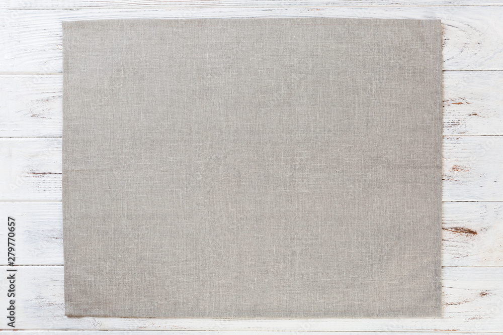 Fototapeta premium gray cloth napkin on white rustic wooden background top view with copy space