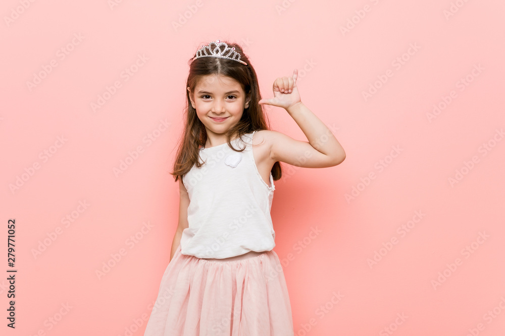Little girl wearing a princess look showing a horns gesture as a revolution concept. Little girl wearing a princess look showing a horns gesture as a revolution concept.
