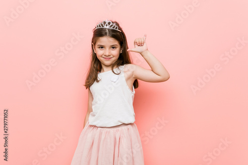 Little girl wearing a princess look showing a horns gesture as a revolution concept.