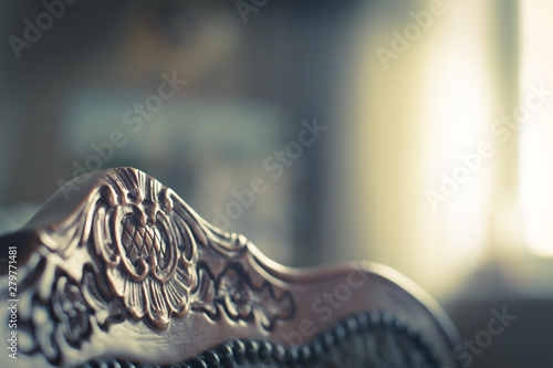 Beautiful vintage chair headboard ornament on background in blur. Side view. Delicate pastel colors