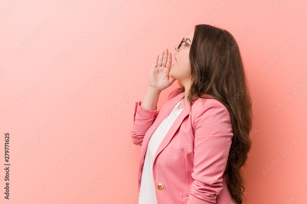 Young plus size business caucasian woman shouting and holding palm near opened mouth. Young plus size business caucasian woman shouting and holding palm near opened mouth.