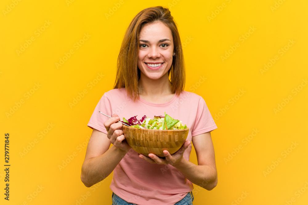 Young healthy woman holding a salad happy, smiling and cheerful. Young healthy woman holding a salad happy, smiling and cheerful.