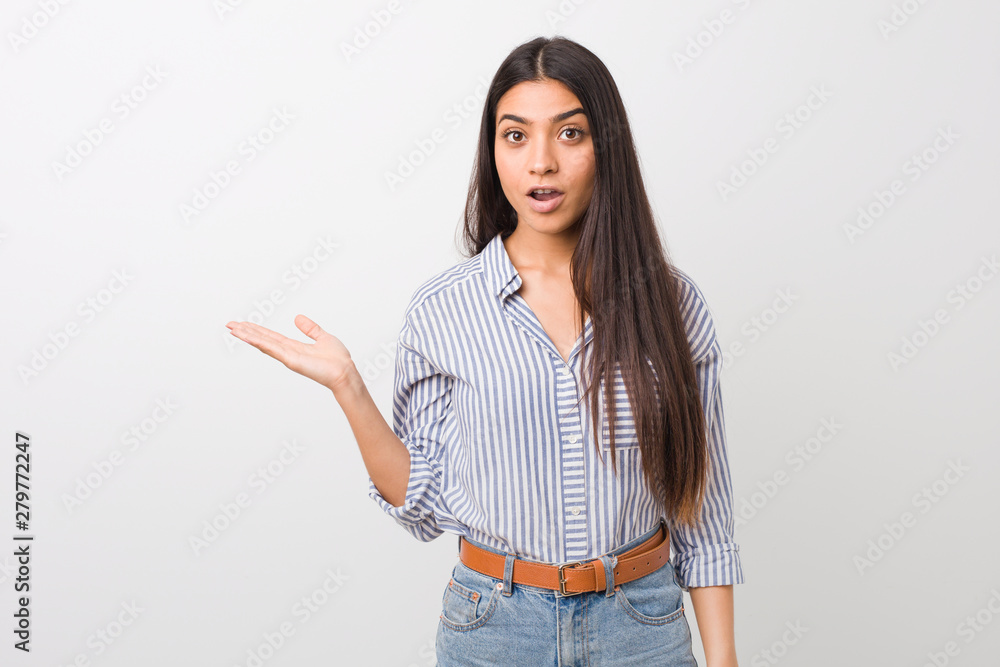 Young pretty arab woman impressed holding copy space on palm. Young pretty arab woman impressed holding copy space on palm.