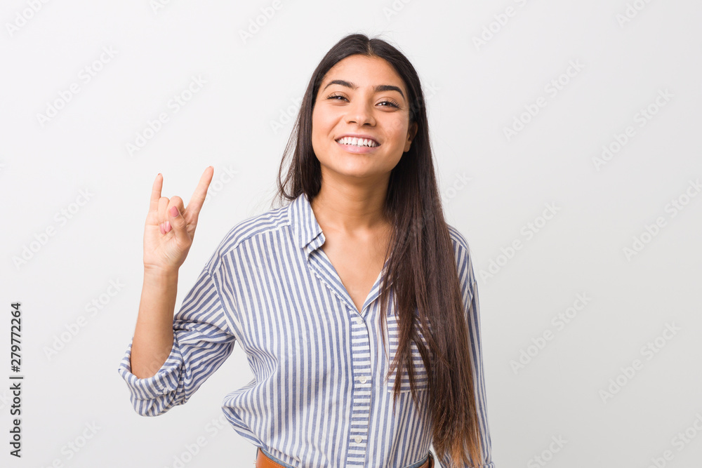 Young pretty arab woman showing a horns gesture as a revolution concept. Young pretty arab woman showing a horns gesture as a revolution concept.