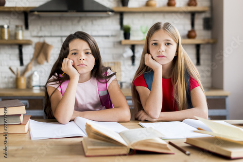 Bored multiethnic schoolgirls doing homework