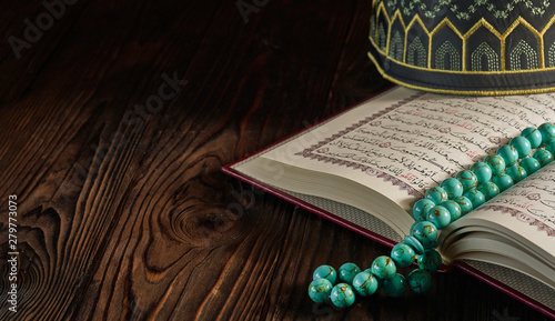 Open Quran book with rosary...