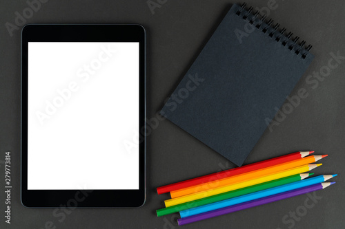 black notebook, lgbt colored pencils and tablet on black paper background. Mock up, Copy space. concept of different views on tolerance, outdated and modern ideas.