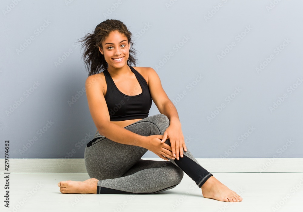 Fototapeta premium Young african american sporty woman sitting practicing yoga