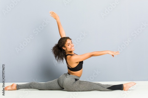 Young african american sporty woman doing rhythmic gymnastics poses