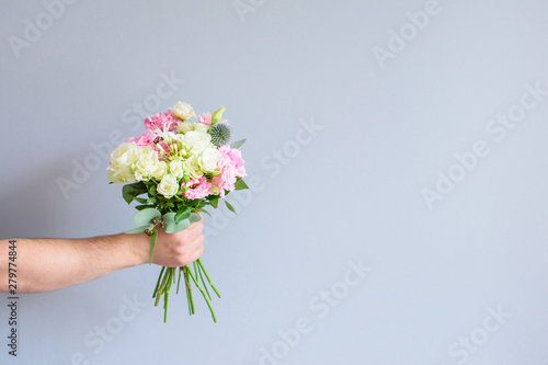 Hand with a bouquet of flowers.