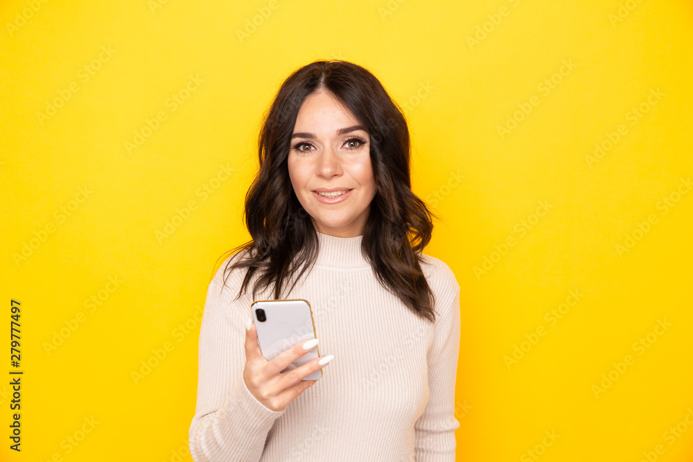 Portrait of female model holding mobile isolated the yellow background Portrait of female model holding mobile isolated the yellow background