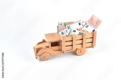 Wooden toy truck with money in the back isolated on white background