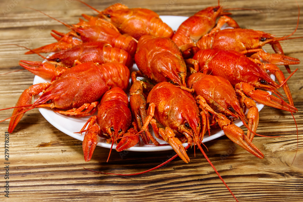 Boiled crayfish in plate on wooden table Boiled crayfish in plate on wooden table