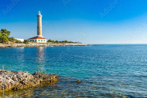 Croatia, island of Dugi Otok, old lighthouse of Veli Rat on the stone shore, beautiful seascape in foreground