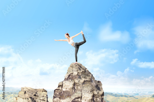 Asian healthy woman practicing yoga on the rock